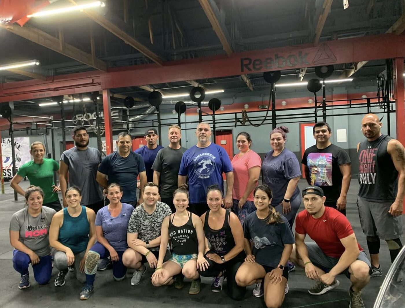 A full class gathered on the gym floor after a workout