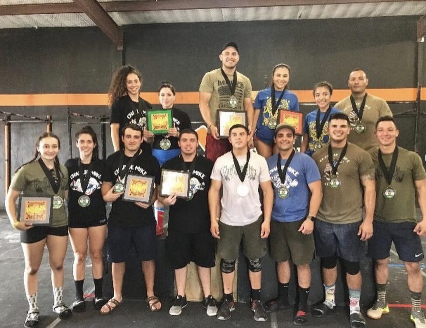 Charlie Mike athletes with medals and plaques after a local competition